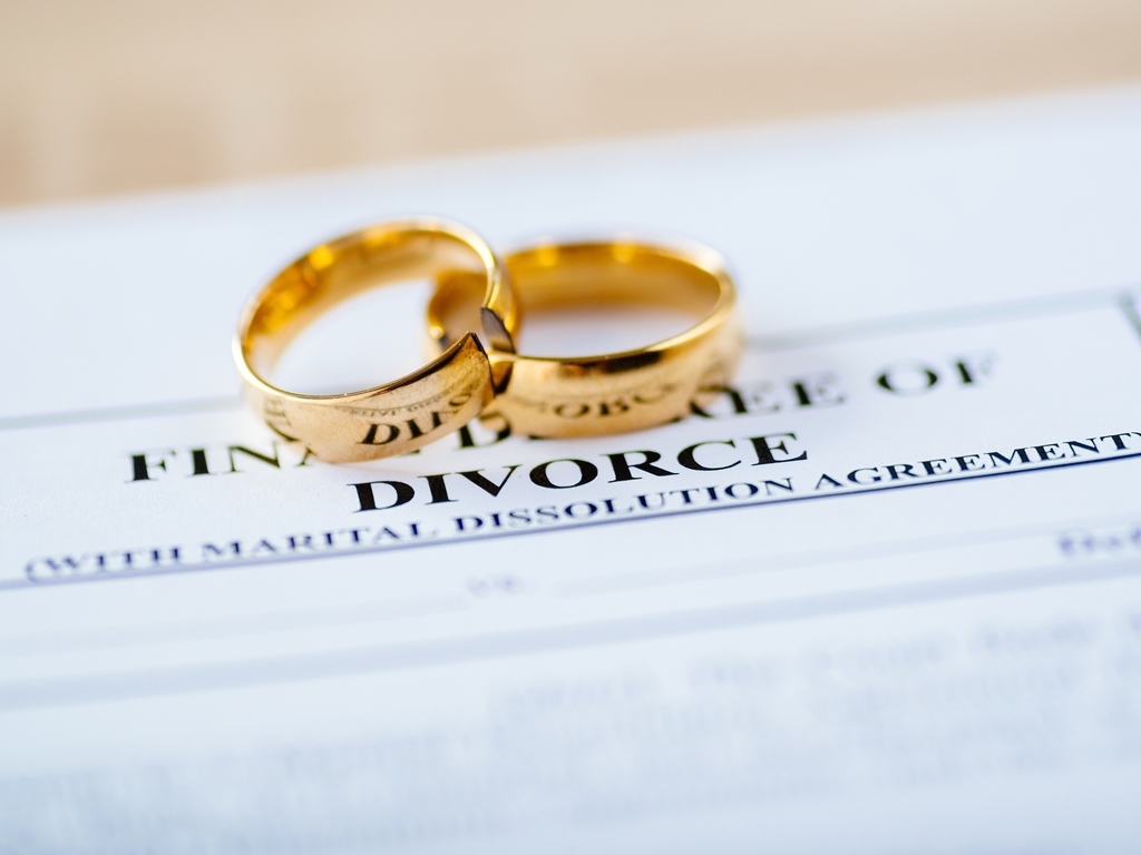 wedding rings sitting on final decree of divorce paperwork