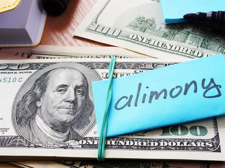 Alimony note on top of hundred dollar bills