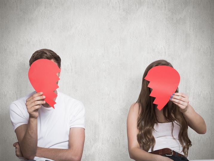 man and woman holding two halves of a heartof a heart
