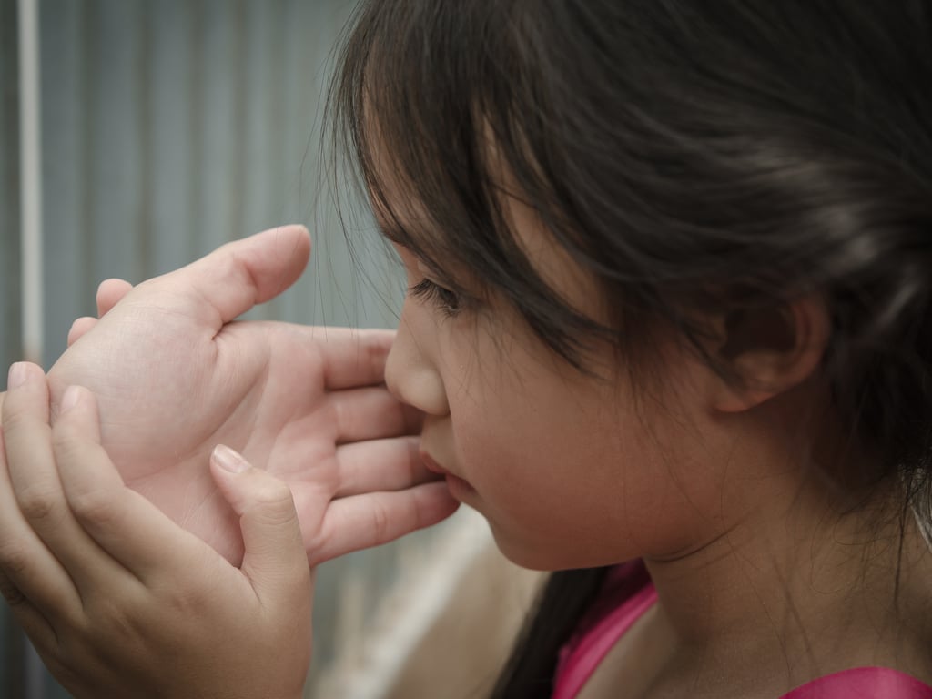 Parent's hand supporting child's face