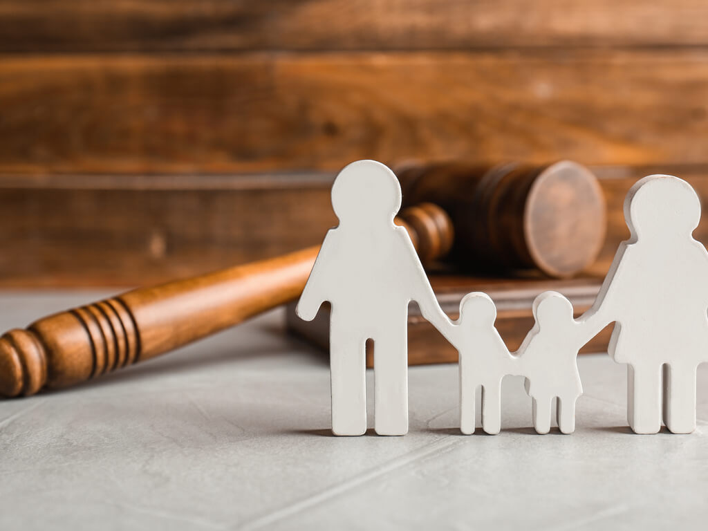 cutout family standing in front of a courtroom gavel