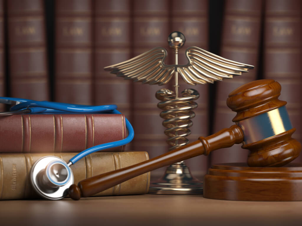 gavel, stethoscope, and caduceus sign on books