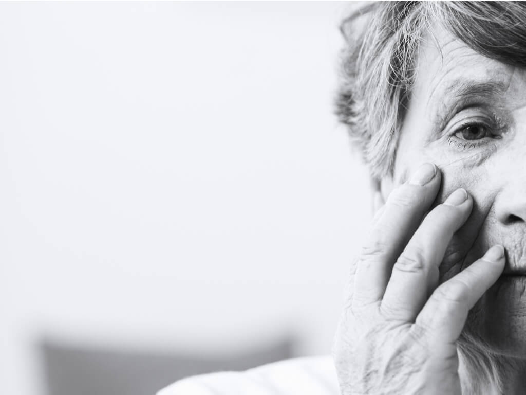 elderly woman holding her face