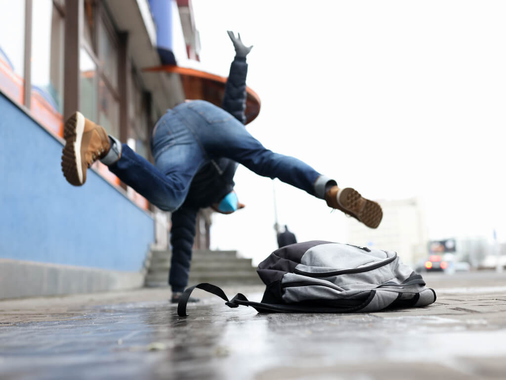 man slipping and falling on sidewalk